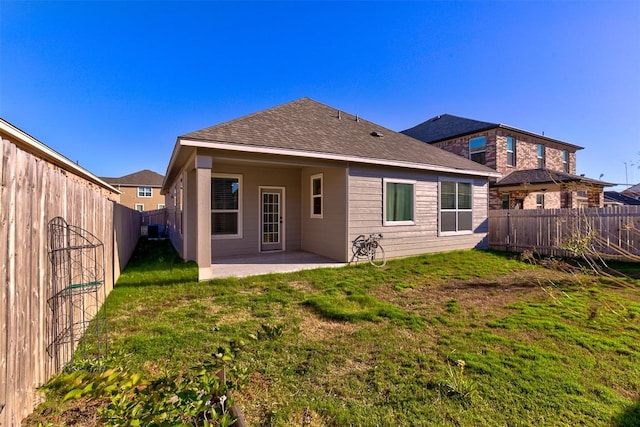 rear view of house featuring a yard and a patio