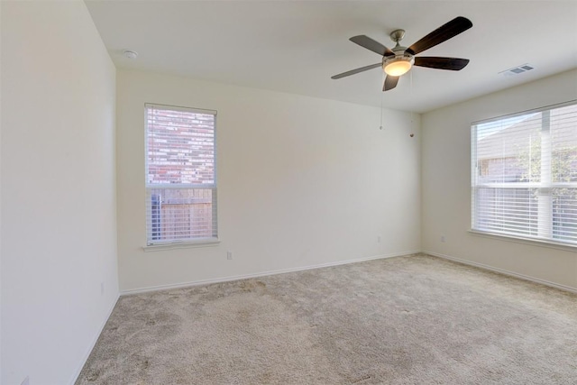 empty room with light carpet, plenty of natural light, and ceiling fan