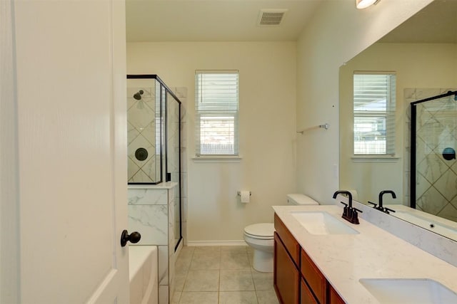 bathroom featuring toilet, vanity, tile patterned floors, and a shower with door