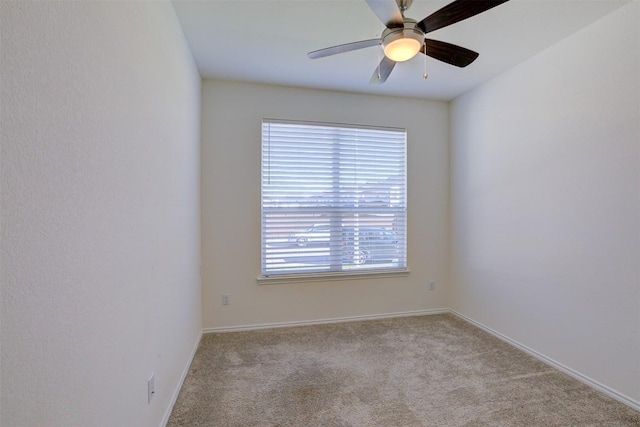 spare room featuring light carpet and ceiling fan