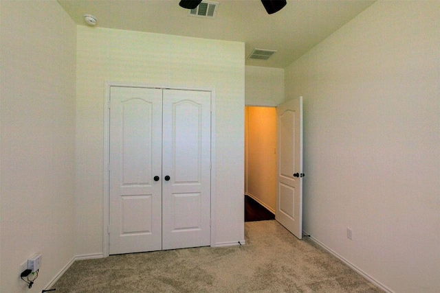 unfurnished bedroom with light colored carpet, a closet, and ceiling fan