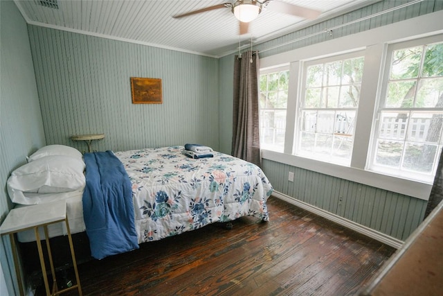 bedroom with dark hardwood / wood-style floors, ceiling fan, and ornamental molding