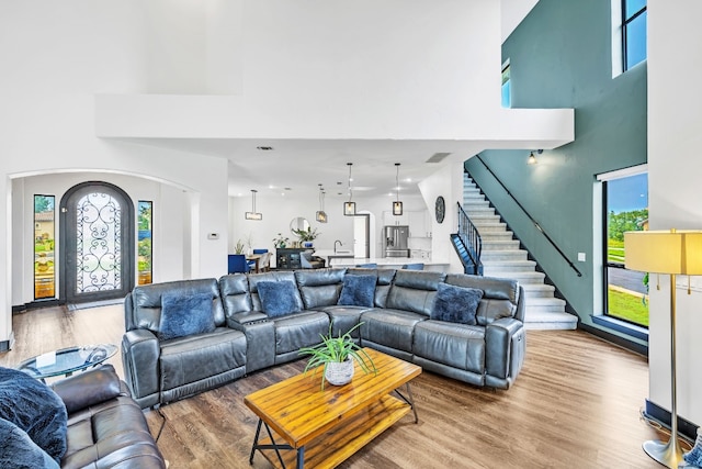 living room with wood-type flooring and a towering ceiling