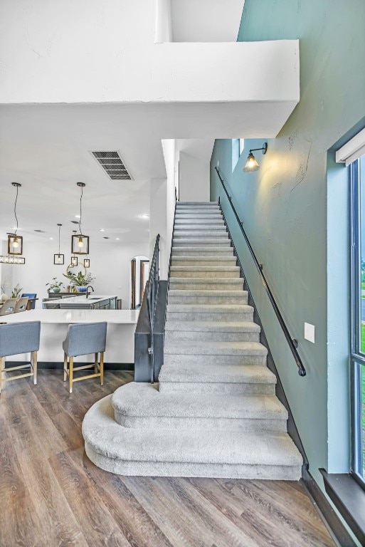 stairs featuring a wealth of natural light and hardwood / wood-style flooring