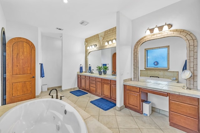 bathroom with a bath, vanity, and tile patterned floors