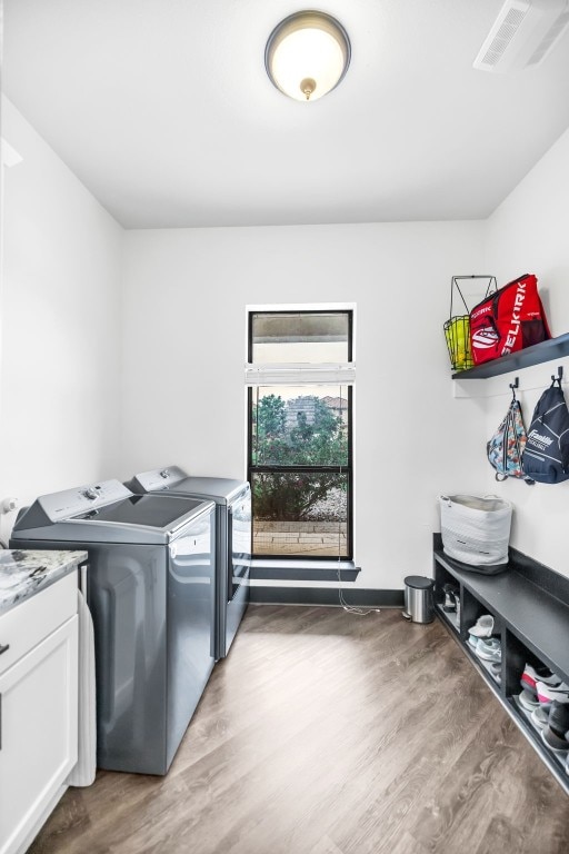 laundry room featuring wood-type flooring and washing machine and dryer