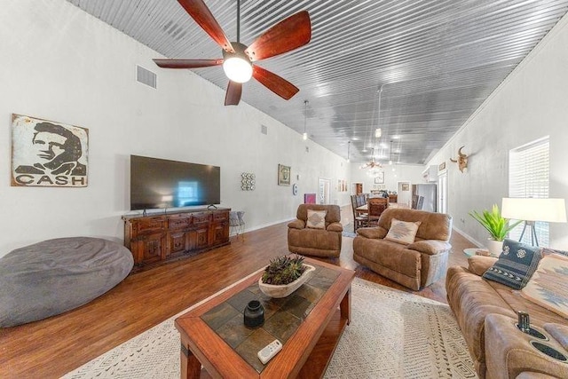 living room featuring hardwood / wood-style floors, high vaulted ceiling, ceiling fan, and crown molding