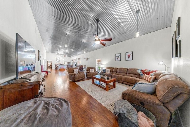 living room with ceiling fan, high vaulted ceiling, and wood-type flooring