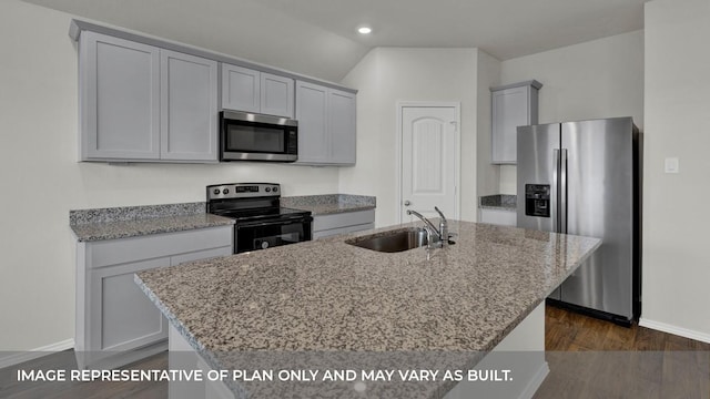 kitchen with light stone counters, stainless steel appliances, a kitchen island with sink, dark wood-type flooring, and sink