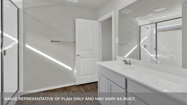 bathroom featuring walk in shower, vanity, and hardwood / wood-style flooring