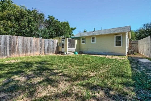 rear view of house featuring a yard and central AC unit