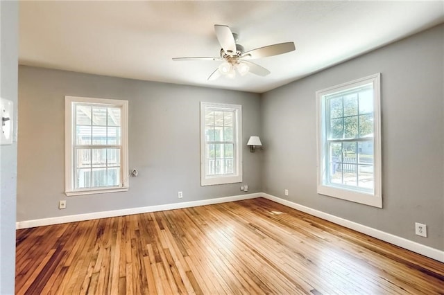 spare room featuring light hardwood / wood-style flooring, ceiling fan, and a healthy amount of sunlight