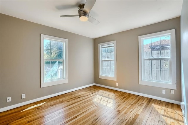 empty room featuring light wood-type flooring, a wealth of natural light, and ceiling fan