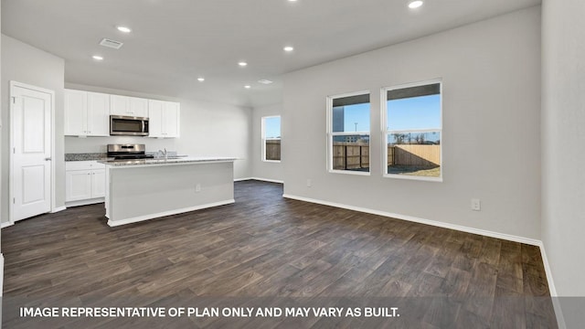 kitchen featuring sink, an island with sink, dark hardwood / wood-style flooring, white cabinetry, and stainless steel appliances