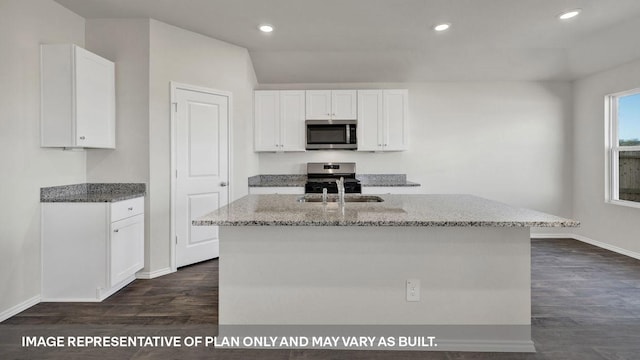 kitchen with white cabinets, light stone countertops, an island with sink, dark hardwood / wood-style flooring, and stainless steel appliances