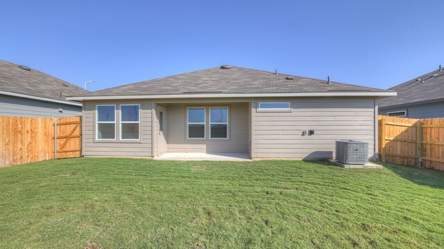 rear view of property featuring a yard, a patio area, and central air condition unit