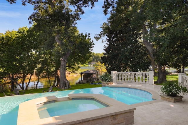 view of pool with an in ground hot tub and a water view