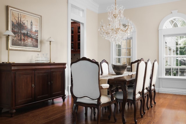 dining room featuring wood-type flooring, ornamental molding, and an inviting chandelier