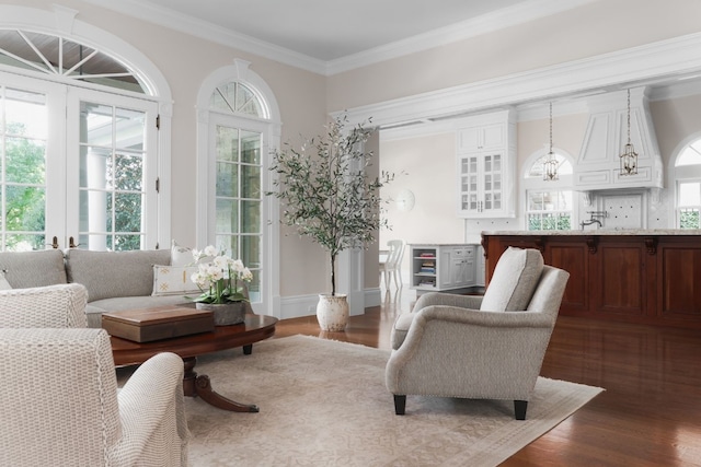 sitting room featuring hardwood / wood-style flooring, plenty of natural light, and crown molding