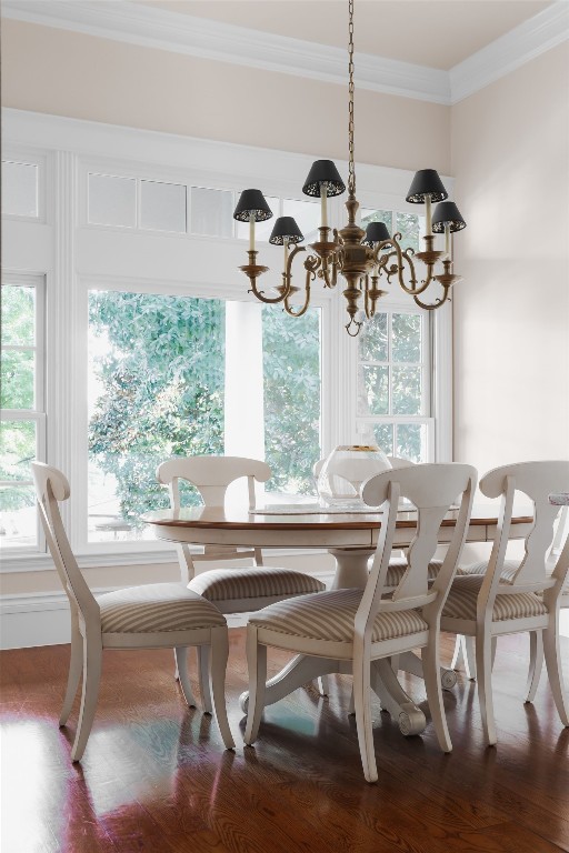 dining area featuring hardwood / wood-style floors, ornamental molding, and a chandelier