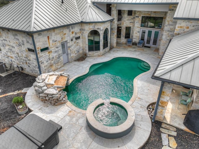 view of swimming pool featuring an in ground hot tub and french doors