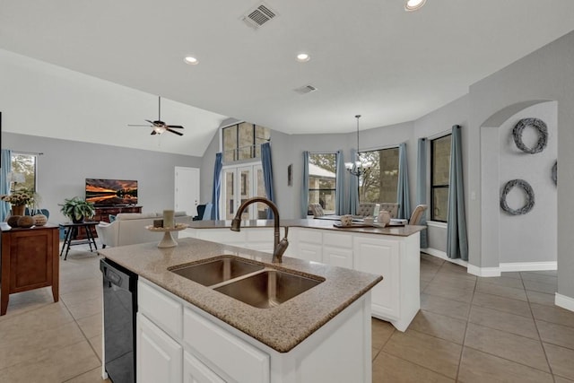 kitchen with black dishwasher, a wealth of natural light, a center island with sink, and sink