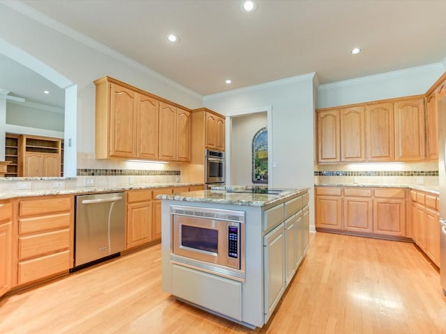 kitchen featuring light stone countertops, light brown cabinets, stainless steel appliances, light hardwood / wood-style flooring, and decorative backsplash