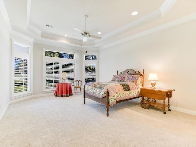 bedroom with a tray ceiling, ceiling fan, carpet flooring, and crown molding