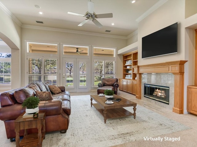 carpeted living room with plenty of natural light, built in features, ornamental molding, and a fireplace