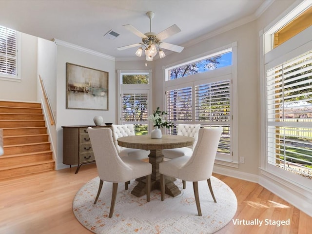 dining area featuring ornamental molding, light hardwood / wood-style floors, and a healthy amount of sunlight