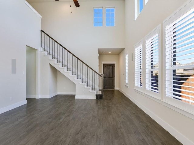 foyer featuring a high ceiling, dark hardwood / wood-style flooring, ceiling fan, and a healthy amount of sunlight