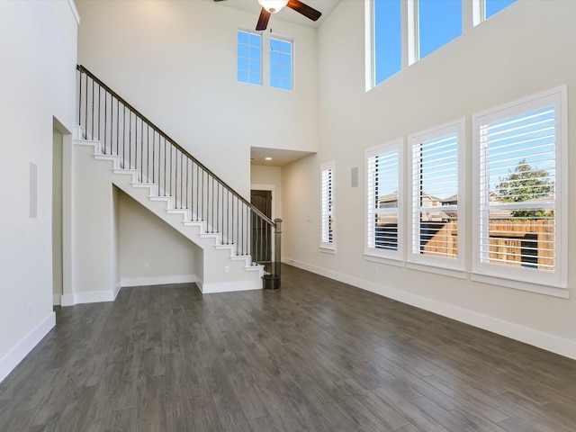 foyer entrance with a high ceiling, dark wood-type flooring, and a healthy amount of sunlight