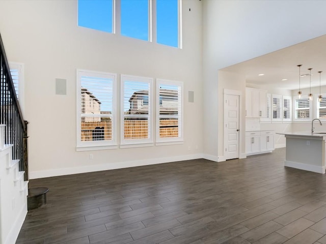 unfurnished living room featuring dark hardwood / wood-style flooring and a wealth of natural light