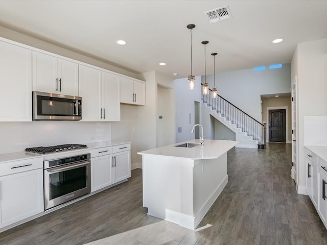 kitchen with white cabinetry, an island with sink, pendant lighting, and appliances with stainless steel finishes