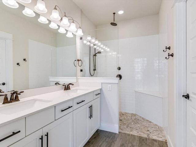 bathroom featuring tiled shower, hardwood / wood-style floors, and vanity