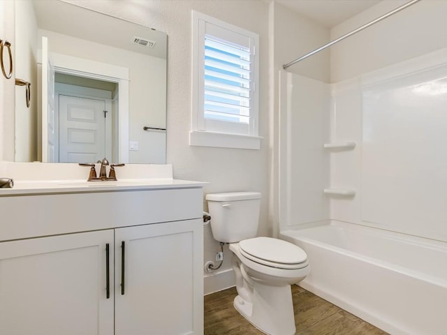 full bathroom with hardwood / wood-style floors, vanity, shower / bath combination, and toilet