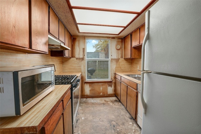 kitchen with decorative backsplash, appliances with stainless steel finishes, and sink