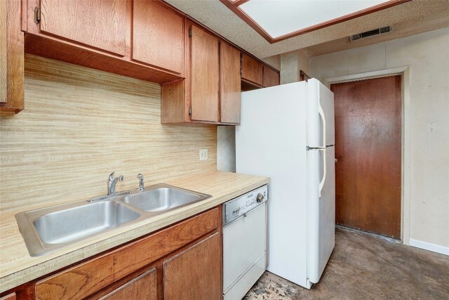 kitchen with a textured ceiling, white appliances, and sink