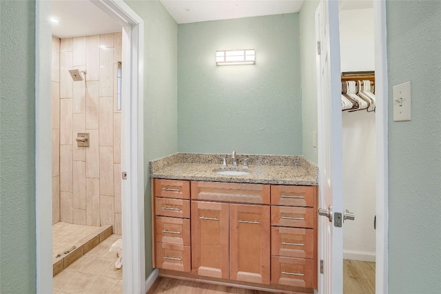 bathroom featuring tile patterned flooring, vanity, and walk in shower