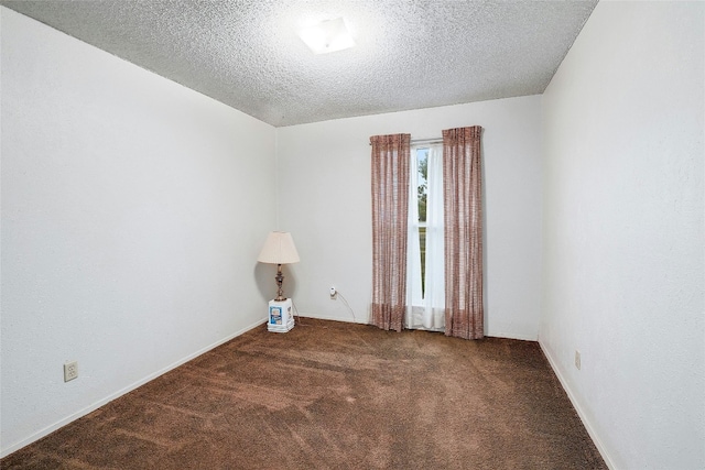 spare room with dark carpet and a textured ceiling