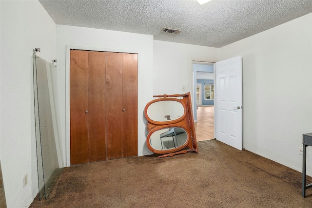 unfurnished room featuring carpet and a textured ceiling