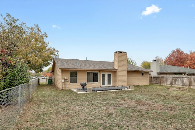 rear view of property with a lawn