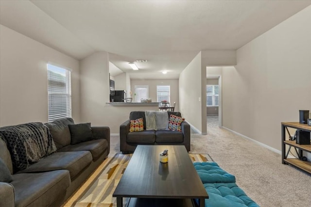 living room with light colored carpet and vaulted ceiling