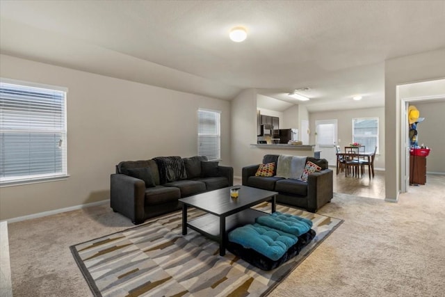 living room featuring light carpet, plenty of natural light, and vaulted ceiling