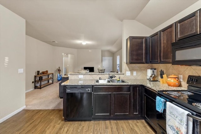 kitchen featuring kitchen peninsula, dark brown cabinets, vaulted ceiling, sink, and black appliances