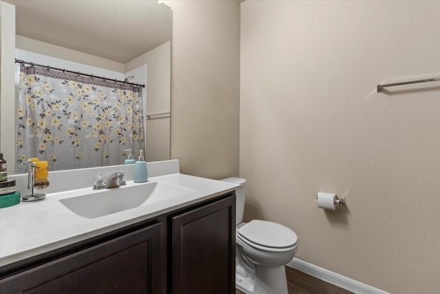 bathroom featuring hardwood / wood-style floors, vanity, toilet, and walk in shower