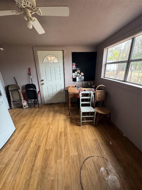 entryway featuring ceiling fan, light hardwood / wood-style floors, and a textured ceiling