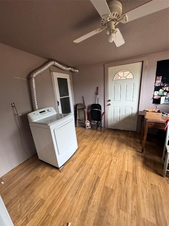 laundry area featuring washer / dryer, light wood-type flooring, a textured ceiling, and ceiling fan