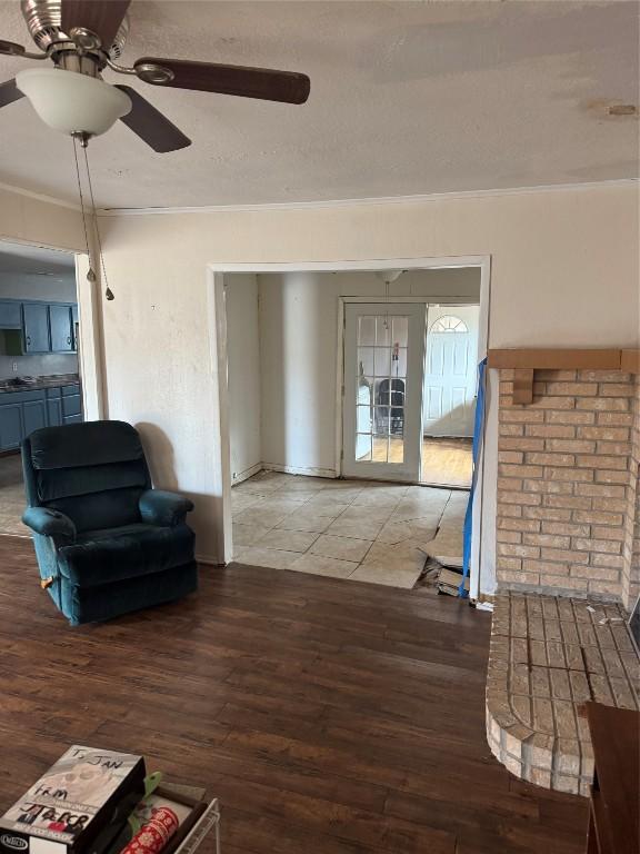 living area featuring hardwood / wood-style flooring, ceiling fan, and crown molding