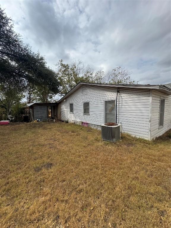 back of property featuring a yard and central AC unit